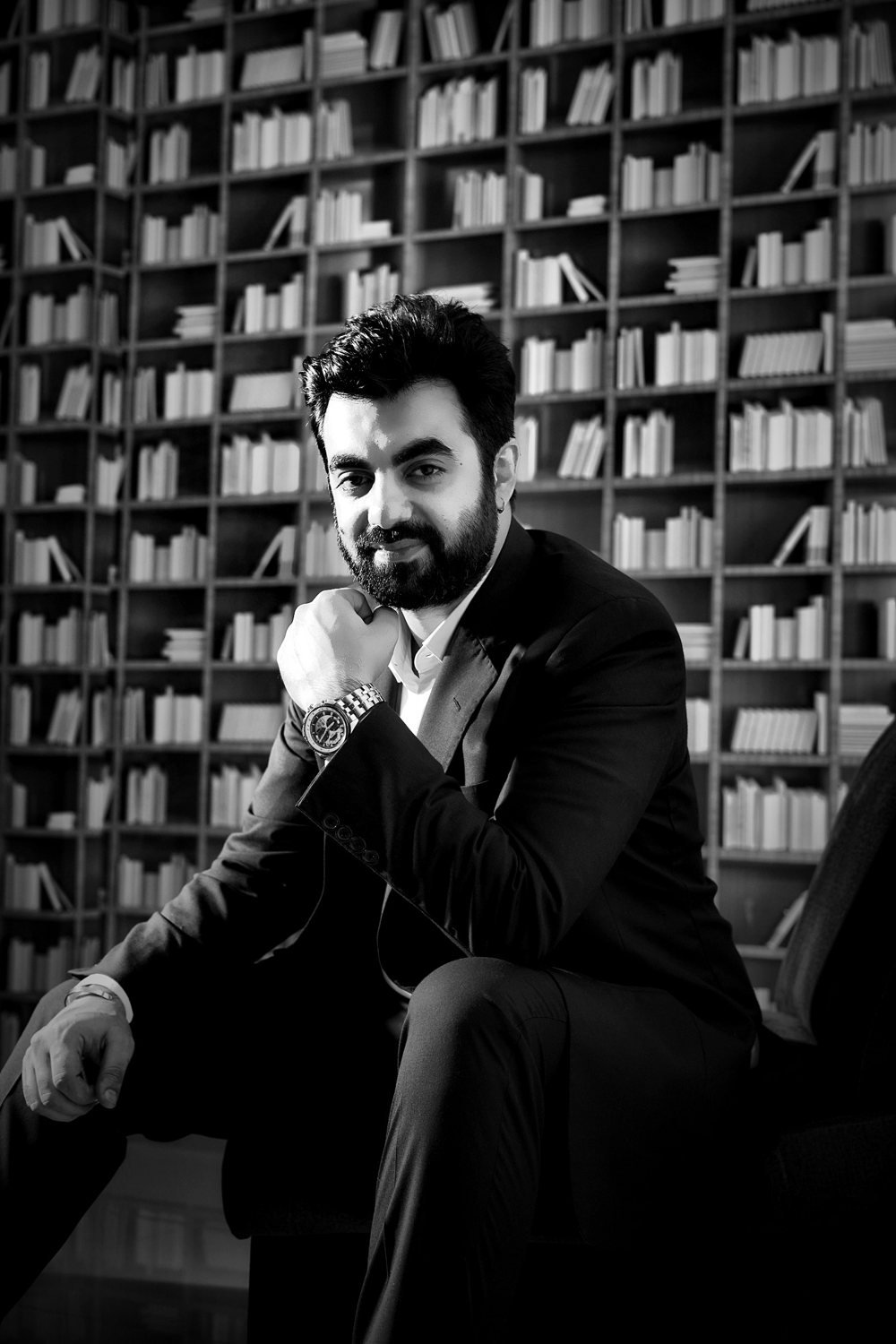 Ghulam Murtaza Memon seated in a library